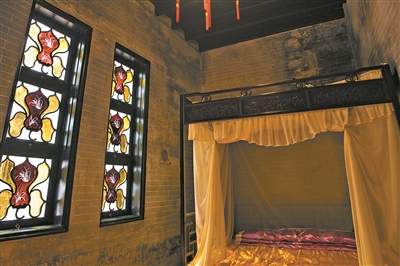 “木棉花”滿洲窗,其中四片花瓣鑲嵌金色玻璃,中心花瓣鑲嵌紅色玻璃。窗芯花瓣玻璃內膽題材為蘭花,猶如在玻璃上“繡花”,展現蘭花蘭葉線條瀟灑之美。