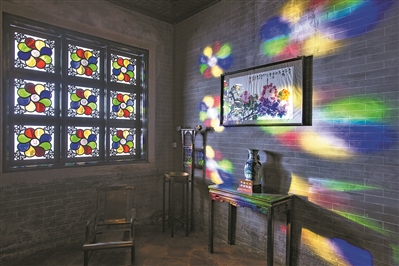 九扇“蝶戀花”方斗組合。八片水滴狀的花瓣各鑲嵌綠、紅、金、藍四色玻璃,四角伴以鏤空木紋蝴蝶裝飾。花瓣呈順時針方向旋轉。四色花瓣分別對應春綠、夏紅、金秋、冬藍,代表著四季更替。