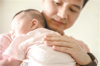 賴永新化身溫柔奶爸，抱著剛出生小女兒哄她入睡。